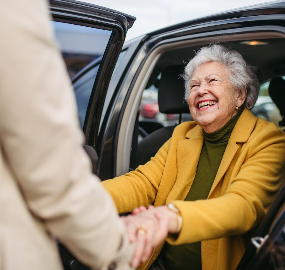 a senior being helped get out of the car in assisted living to prevent a fall